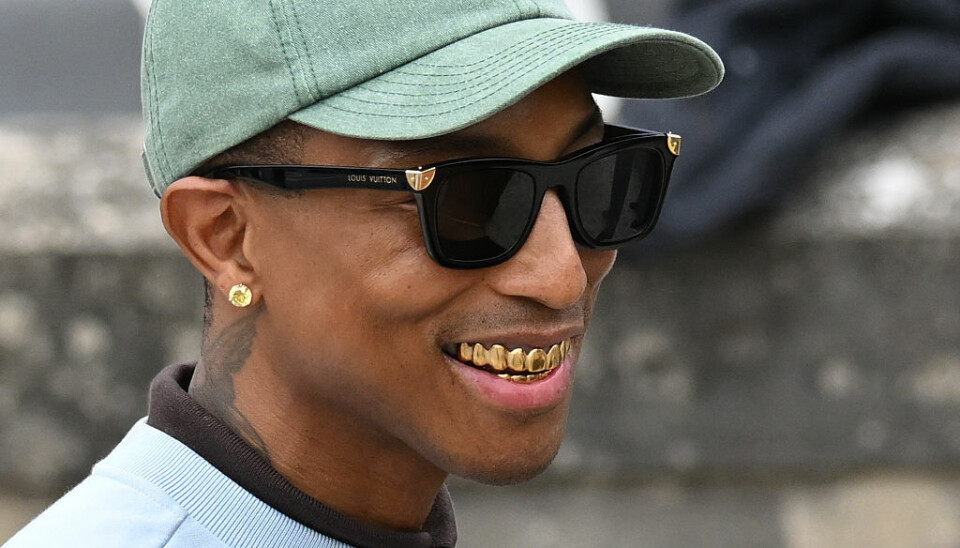 Pharrell Williams attends the Dior Homme Menswear Spring/Summer 2026 show as part of Paris Fashion Week on June 27, 2025 in Paris, France. Pharrell showing off a gold grill.