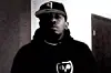 A grainy black and white photo of a black man in a hat and hoodie.