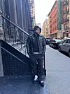 Spanish Ran in black sweats and a black leather jacket posing for a photo on a new york street.