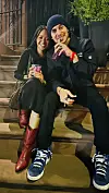 Adelfa Marr and Manny Montana sitting on an apartment building stoop sipping on smoothies