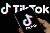 CHONGQING, CHINA - JANUARY 23: In this photo illustration, a person holds a smartphone displaying the TikTok logo, with the TikTok brand visible in the background, on January 23, 2026, in Chongqing, China. In a post shared earlier in the day on Truth Social, U.S. President Donald Trump said he helped keep TikTok operating in the United States, citing efforts involving American investors and discussions with Chinese counterparts, and expressed appreciation for Chinese President Xi Jinping's approach toward allowing the deal to proceed amid ongoing U.S. national security scrutiny. (Photo illustration by Cheng Xin/Getty Images)