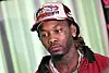 Offset wearing a colorful trucker hat and red jacket at a charity event in Georgia