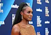 Issa Rae in a gold dress on the blue carpet at the Film Independent Spirit Awards.
