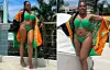Woman in green bikini and bright cover-up posing on outdoor resort terrace