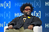 Questlove seated in a chair onstage at the HumanX Conference panel discussion.