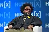 Questlove seated in a chair onstage at the HumanX Conference panel discussion.