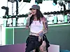 Kehlani performing on an outdoor stage at the REVOLVE Festival with mic in hand.