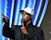 Damon Wayans holding a microphone and pointing while performing onstage