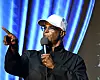 Damon Wayans holding a microphone and pointing while performing onstage