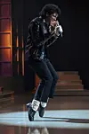 Jaafar Jackson as Michael Jackson dancing mid-step on a lit stage.