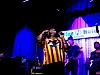 Singer with band performing on stage at Blue Note New York under blue and purple lights