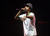 Earl Sweatshirt performing on stage with a microphone at an outdoor concert