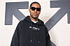 Kid Cudi wearing a black hoodie and sunglasses at an Off-White fashion show.
