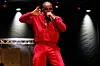 T.I. performs onstage in a red outfit under spotlights at DC Emancipation Day.