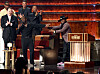Kevin Hart and Katt Williams speak onstage beside a podium at The Kia Forum during a Netflix roast event.