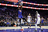 A Knicks player dunks over 76ers defenders during an NBA playoff game in Philadelphia.