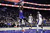 A Knicks player dunks over 76ers defenders during an NBA playoff game in Philadelphia.