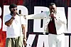 Two performers onstage at Roots Picnic, one holding a microphone and the other gesturing beside him.