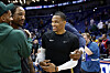 Russell Westbrook stands courtside smiling with people around him after a game in New Orleans.