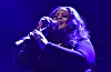 Maysa sings into a microphone on a blue-lit stage at the O2 Forum Kentish Town.
