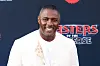 Idris Elba smiles at the 'Masters of the Universe' world premiere in front of a promotional backdrop.