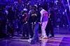 Wu-Tang Clan members perform on the basketball court under purple lighting at Madison Square Garden.