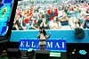 A performer on stage faces a cheering crowd shown on a large screen at a FIFA World Cup event.