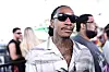 Wiz Khalifa wearing sunglasses at the REVOLVE Festival with people blurred behind him.