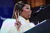 Nicki Minaj speaks at a podium beside a microphone during a Treasury Department summit in Washington, DC.