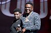Boosie smiles while holding a microphone onstage at a music festival in Atlanta.