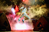 Tyler, The Creator jumps above the stage amid colorful smoke, lights, and speakers at Camp Flog Gnaw.
