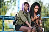 Michaela Coel sitting with Weruche Opia who is on phone