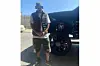 DJ Muggs stands outside a suped up truck in camo shorts and a puffer vest.