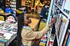 Beautiful university student reaching books on upper shelves in the library.