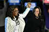 Oprah Winfrey (L) holds up US Vice President and Democratic presidential candidate Kamala Harris' hand as she arrive onstage during a campaign rally on the Benjamin Franklin Parkway in Philadelphia, Pennsylvania, on November 4, 2024.