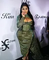 Lil' Kim wearing a glittery green dress on a red carpet