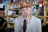 Mac Miller wearing a brown hat with gold rings