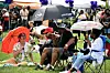 Festival goers laugh in the shade of umbrellas brought to ward off the forecasted storms at BAMFest in Franklin Park, June 24, 2023.