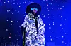 Erykah Badu performing in all blue and glasses