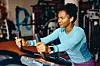 Smiling African American athletic woman cycling on stationary bike in a gym.