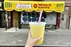 A fruit smoothy in front of a storefront.