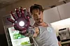 Tony Stark holds the Iron Man hand up to the camera.