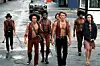 In a scene from the film 'The Warriors' (directed by Walter Hill), members of the titular gang walk west along Bowery Street in Coney Island, New York, New York, 1979.