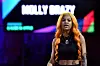 Molly Brazy female rapper with orange hair and chain onstage