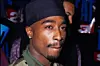 2Pac in a camo shirt and durag.
