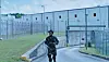 Shameik Moore wearing an all camo outfit and leaving what appears to be a prison.