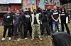 A group of Black men stand together outside a street mural.